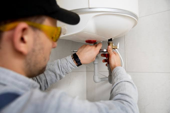 Plomero profesional instalando calefón en pared